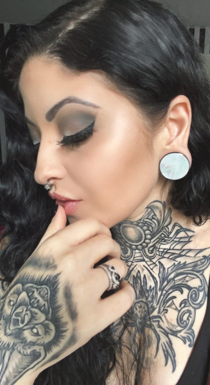 Model wearing Mother of pearl stainless steel plugs